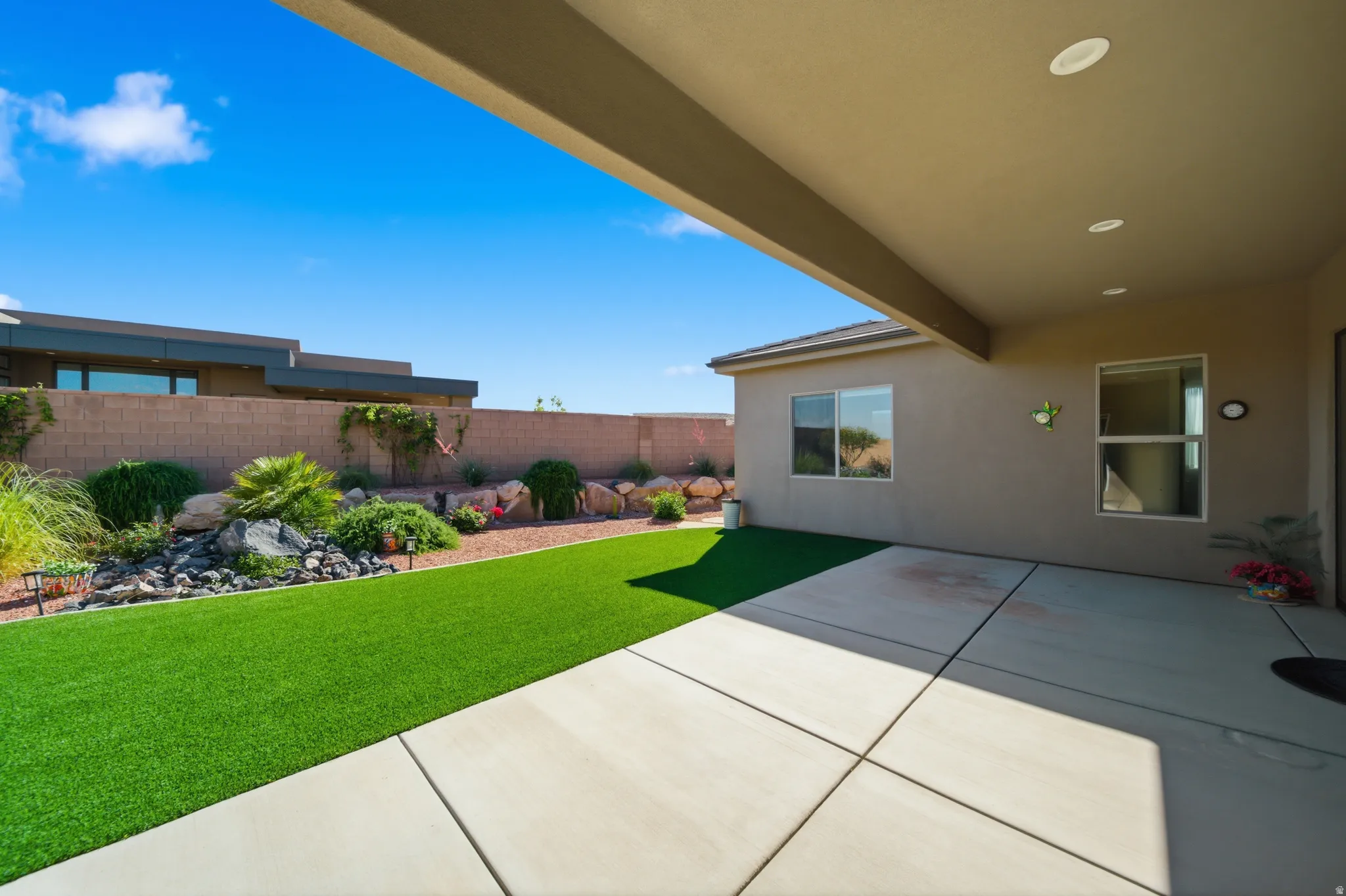 Expansive covered patio with recessed lighting, concrete flooring, and a stucco finish