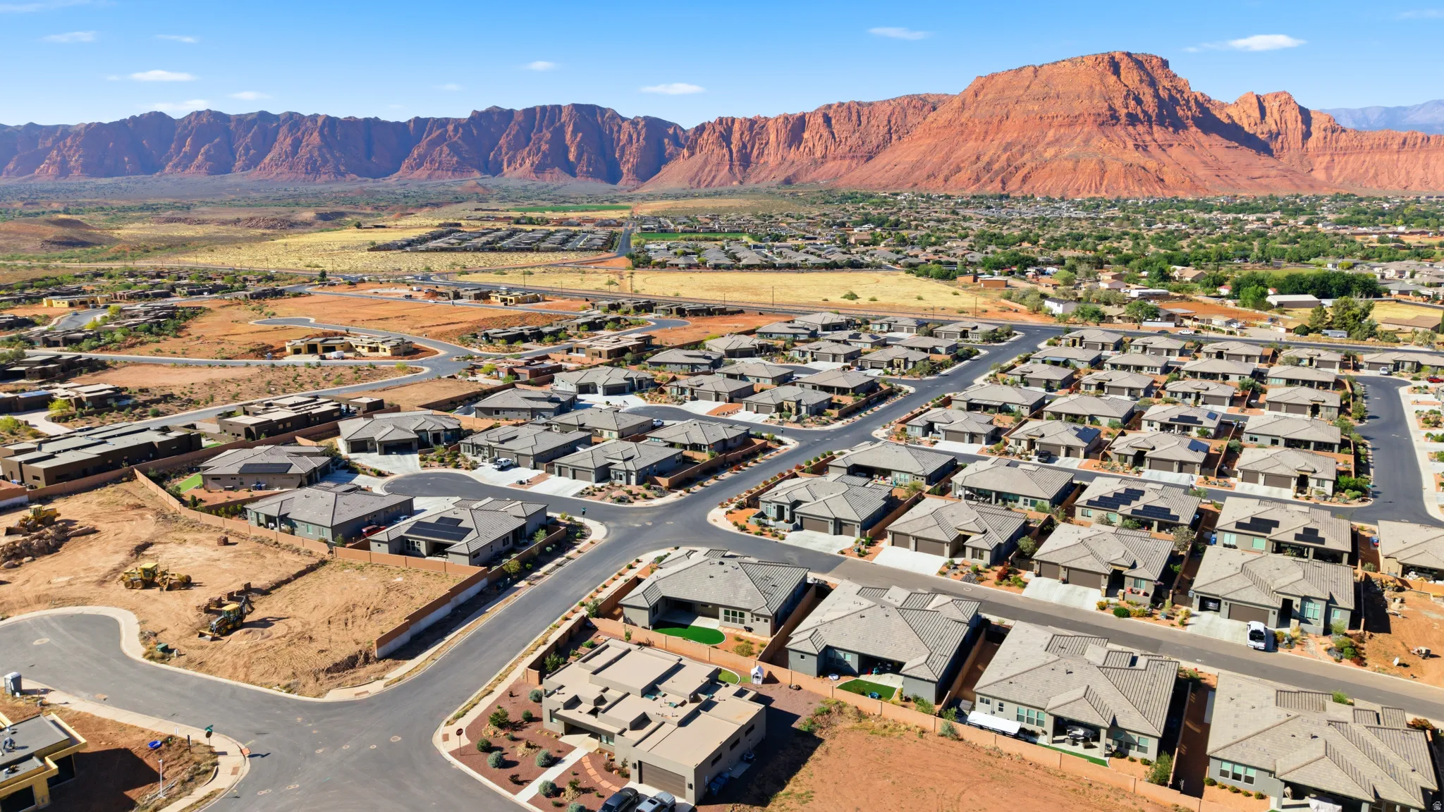 New construction residential development featuring a collection of single-story homes with attached garages, gray-toned roofing, and desert landscaping