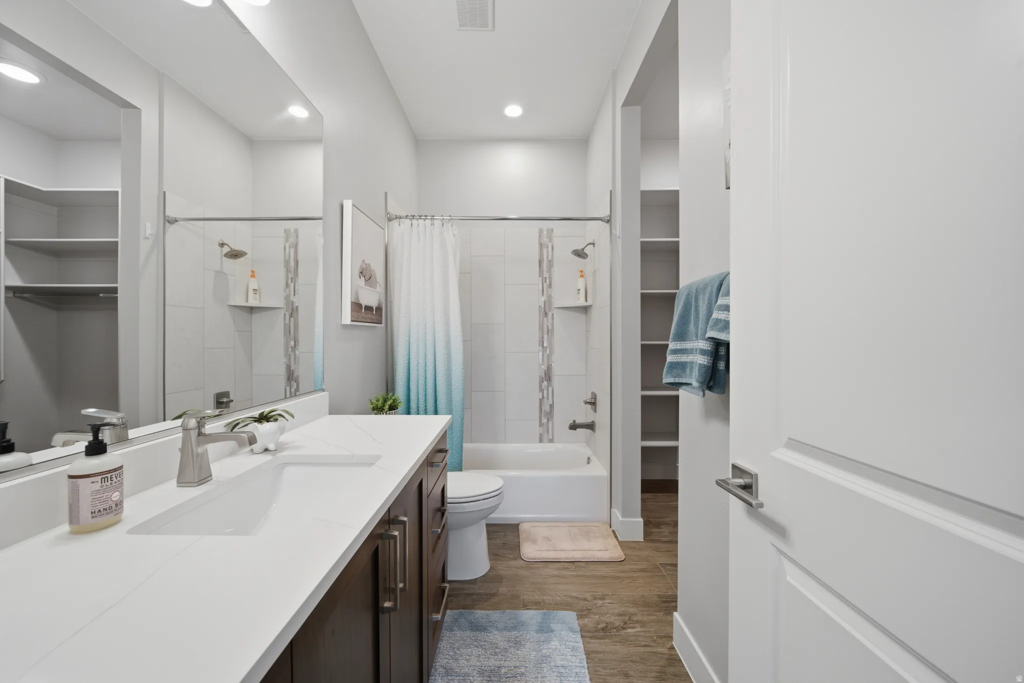 Bathroom featuring a double vanity with white countertops, integrated sinks, and dark wood-finish cabinetry