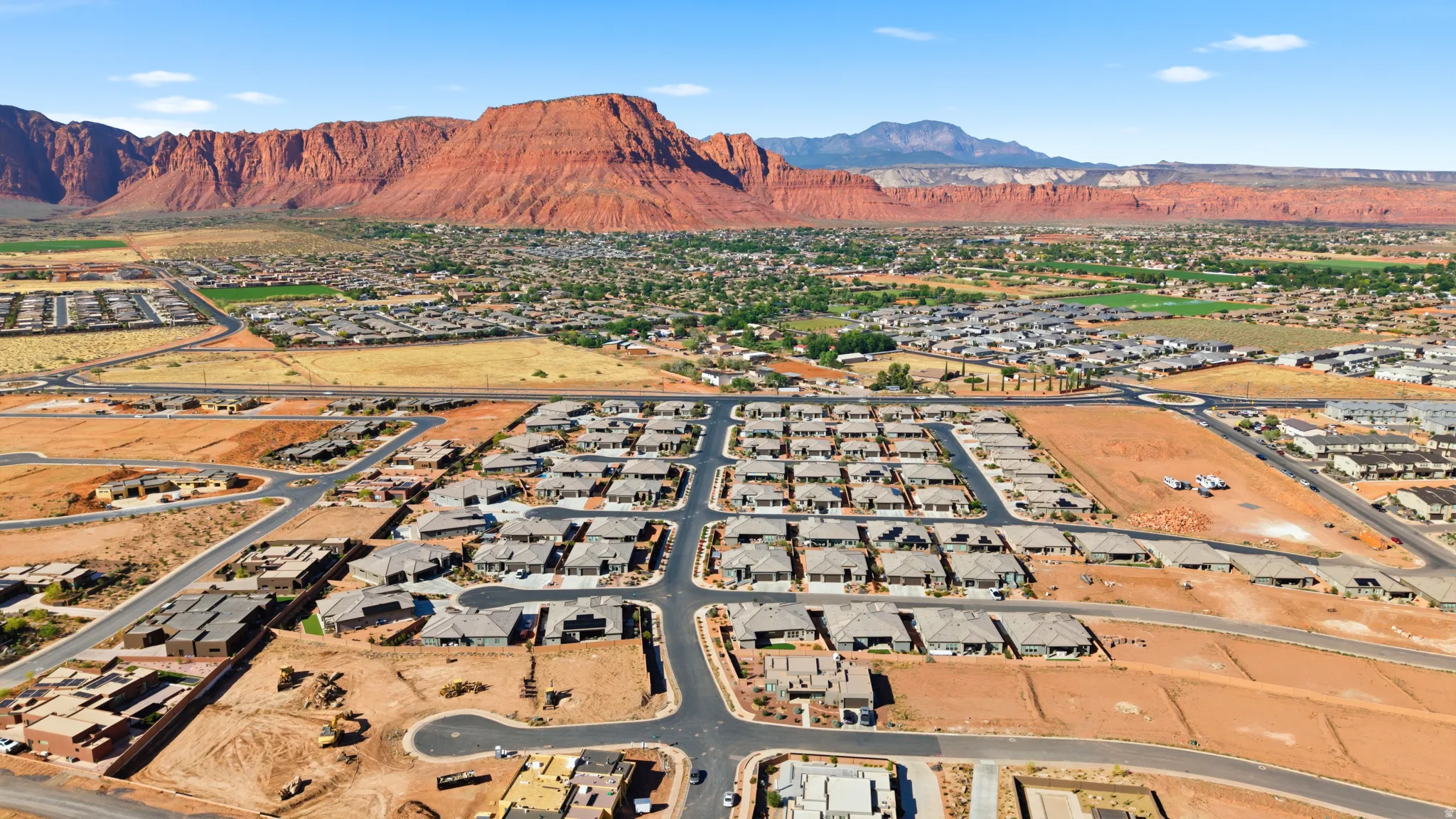 Expansive residential development featuring numerous single-story properties with gray roofing and paved street infrastructure