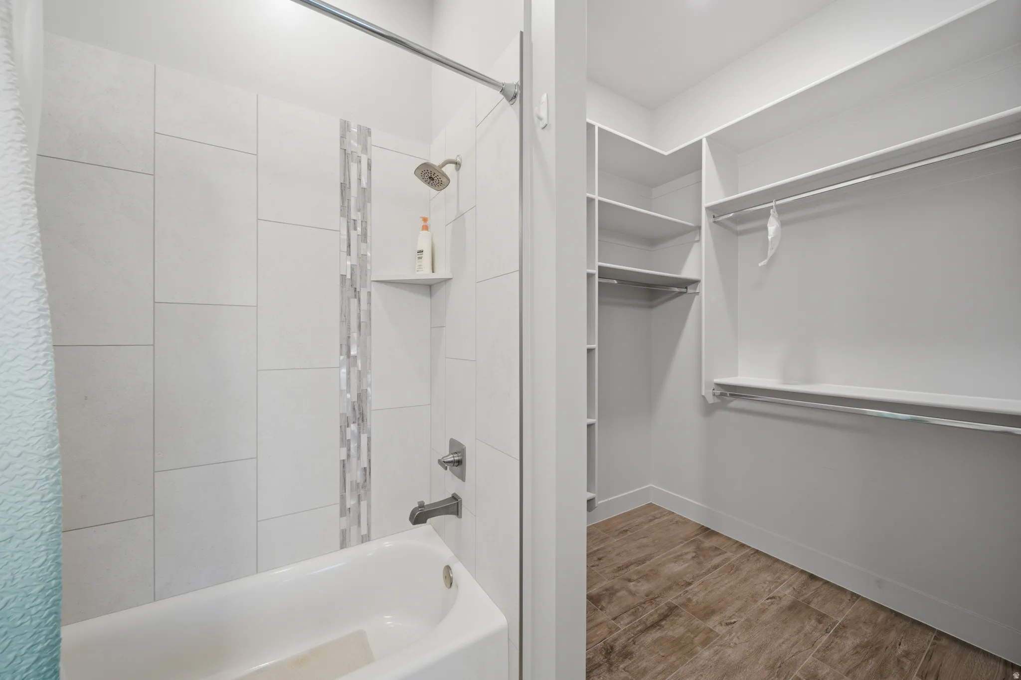 Bathroom featuring a white subway tile surround with a decorative mosaic accent and a built-in shower niche