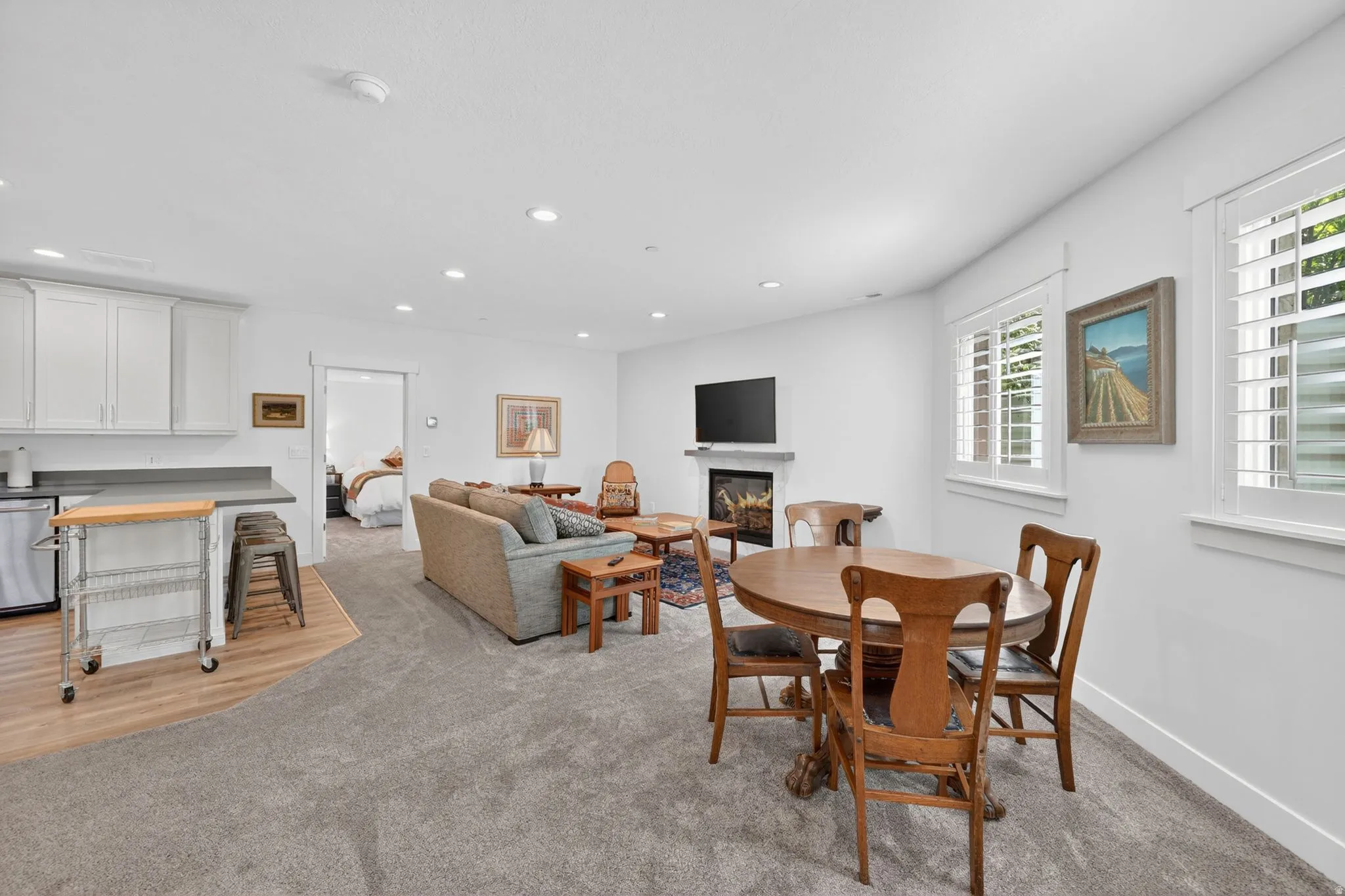 Mother in Law - Open-concept living space featuring recessed lighting, a built-in electric fireplace, and white plantation shutters on multiple windows