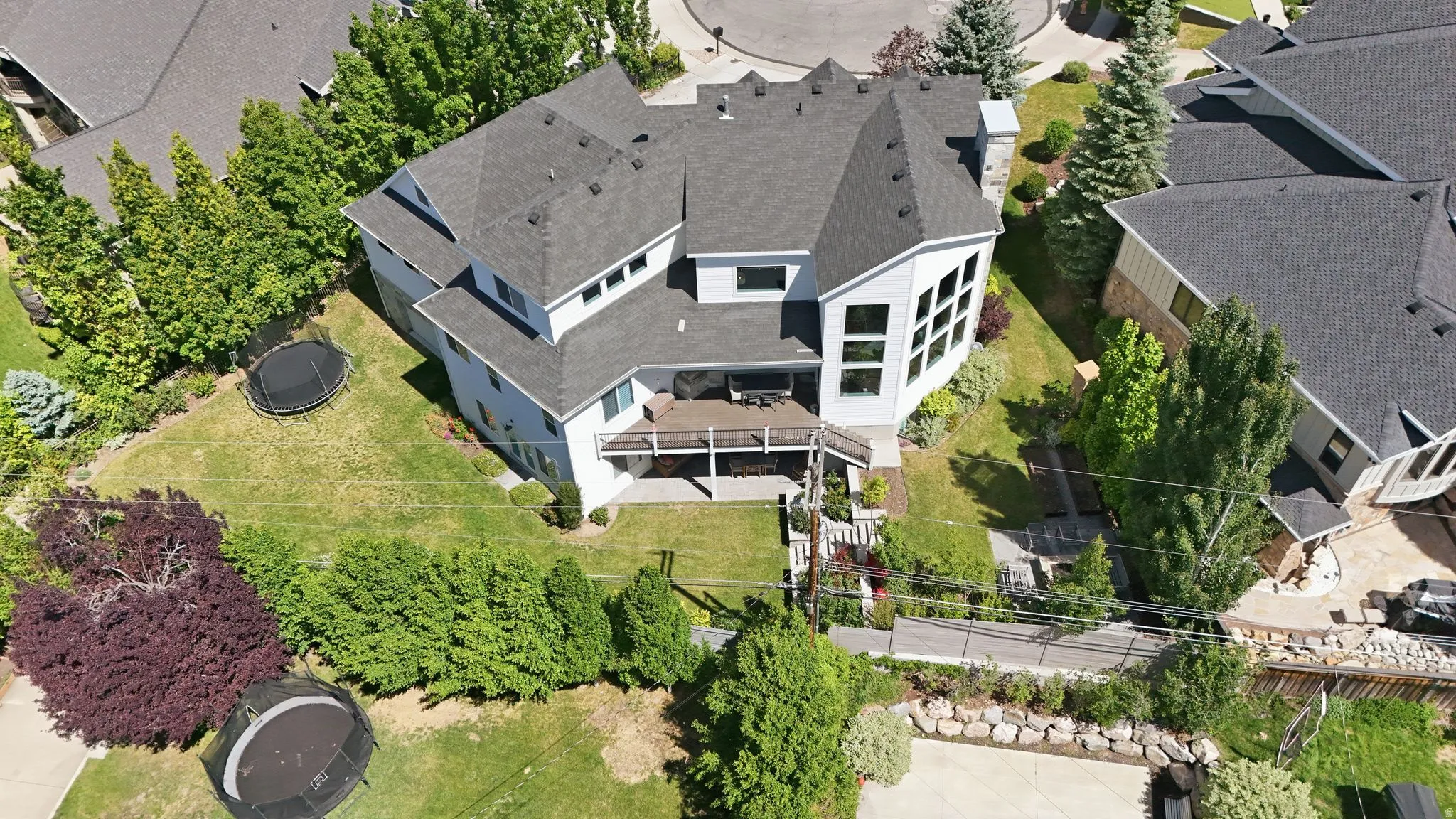 Two-story residence featuring a multi-level deck and an expansive lawn