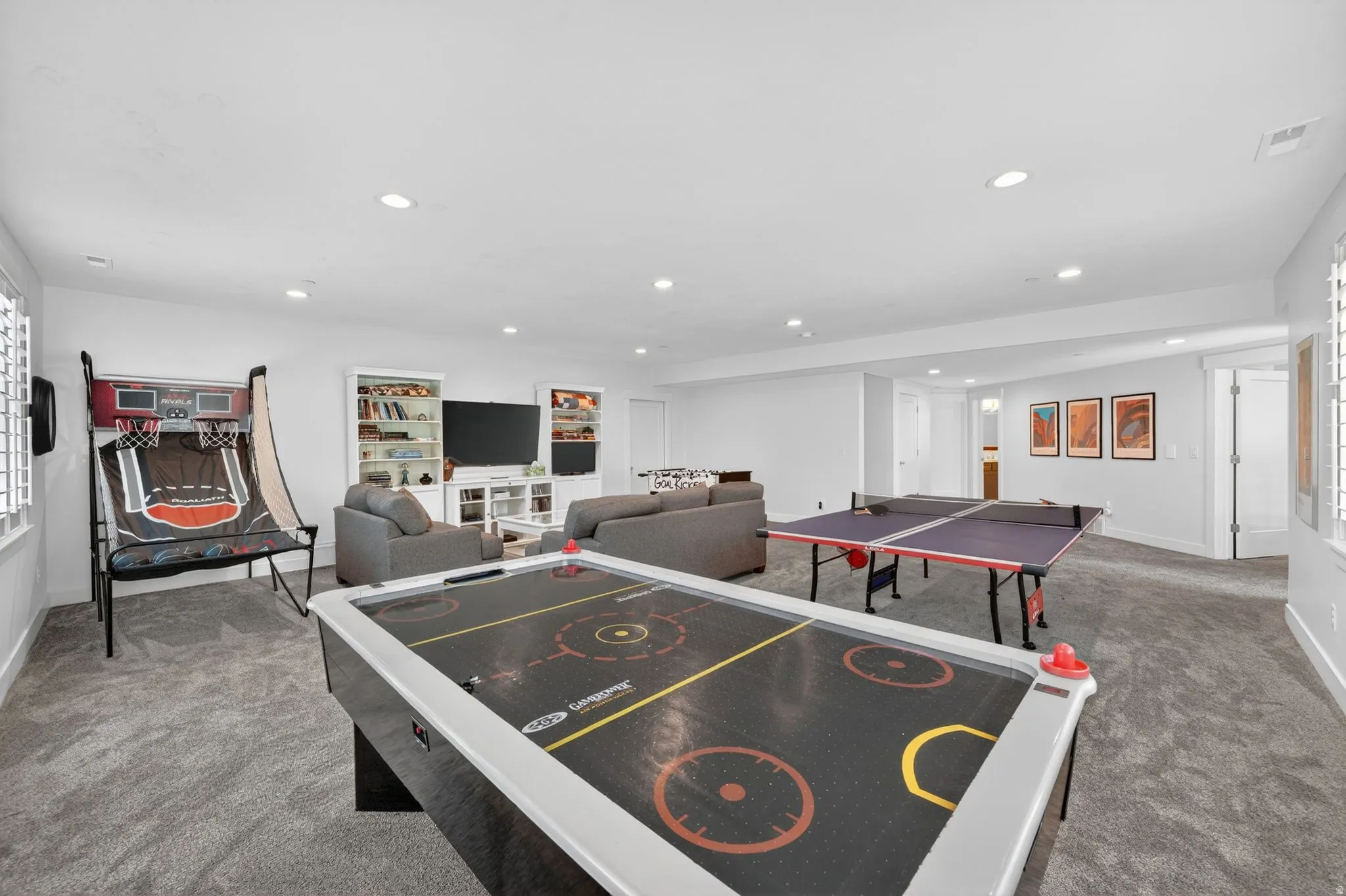 Spacious room featuring neutral carpeting, recessed lighting, and white walls