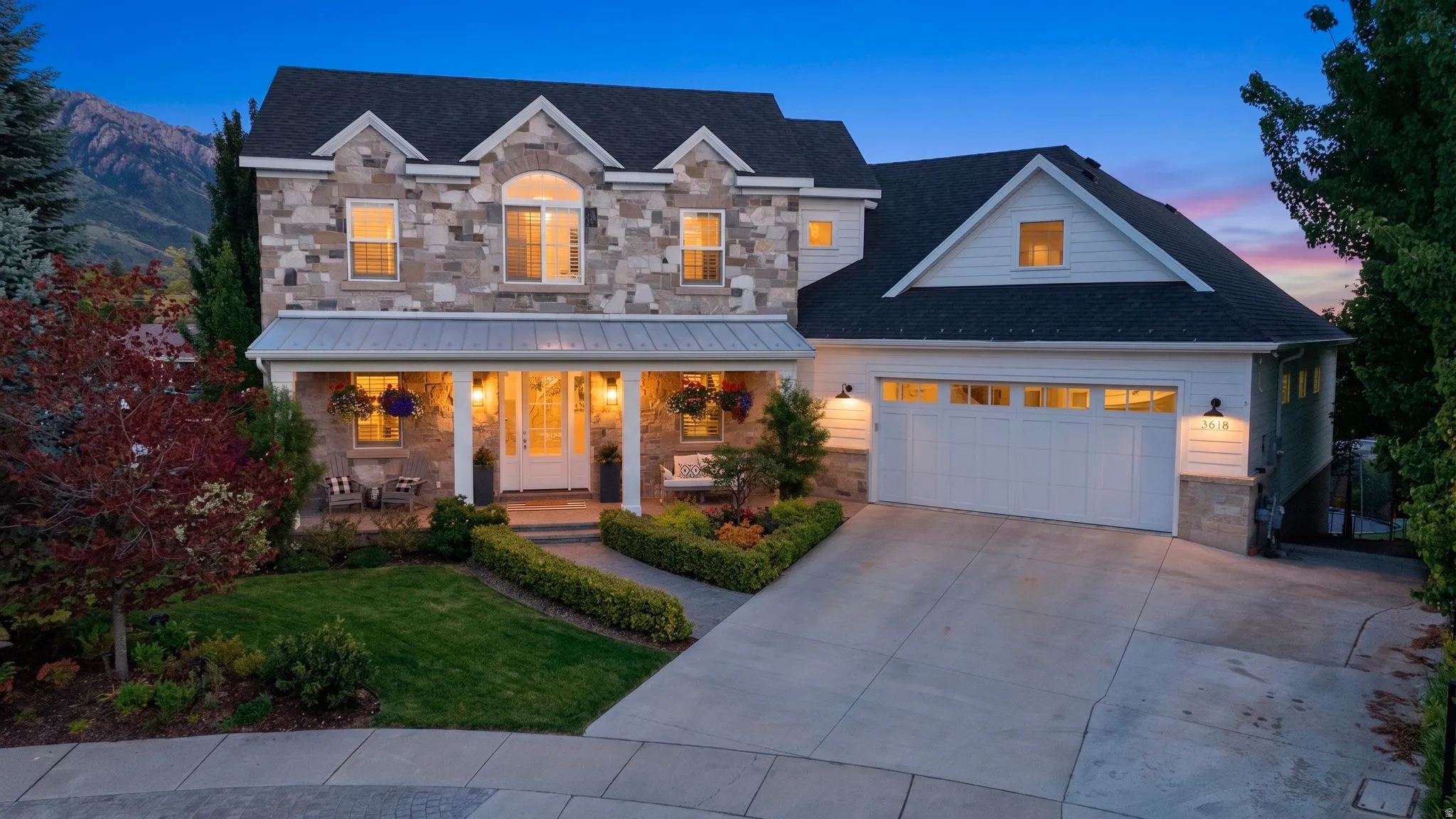 Stone and siding exterior with a dark roof and white trim