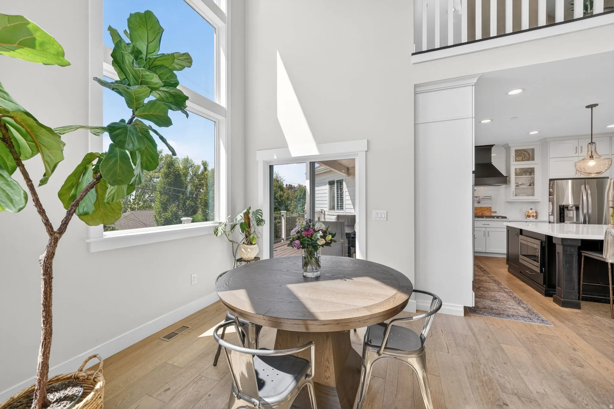 Dining area featuring soaring ceilings and light wood-finish flooring