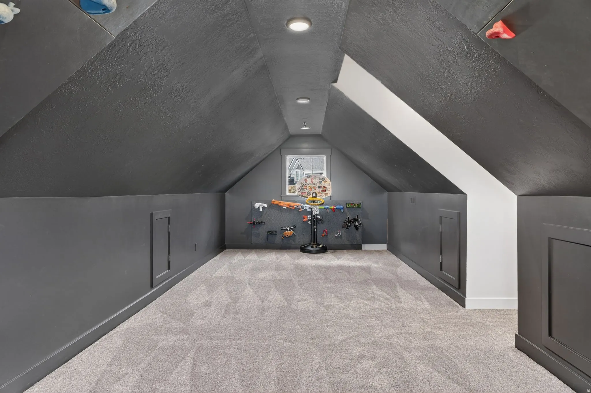 Attic space featuring sloped ceilings, recessed lighting, and light-toned patterned carpeting