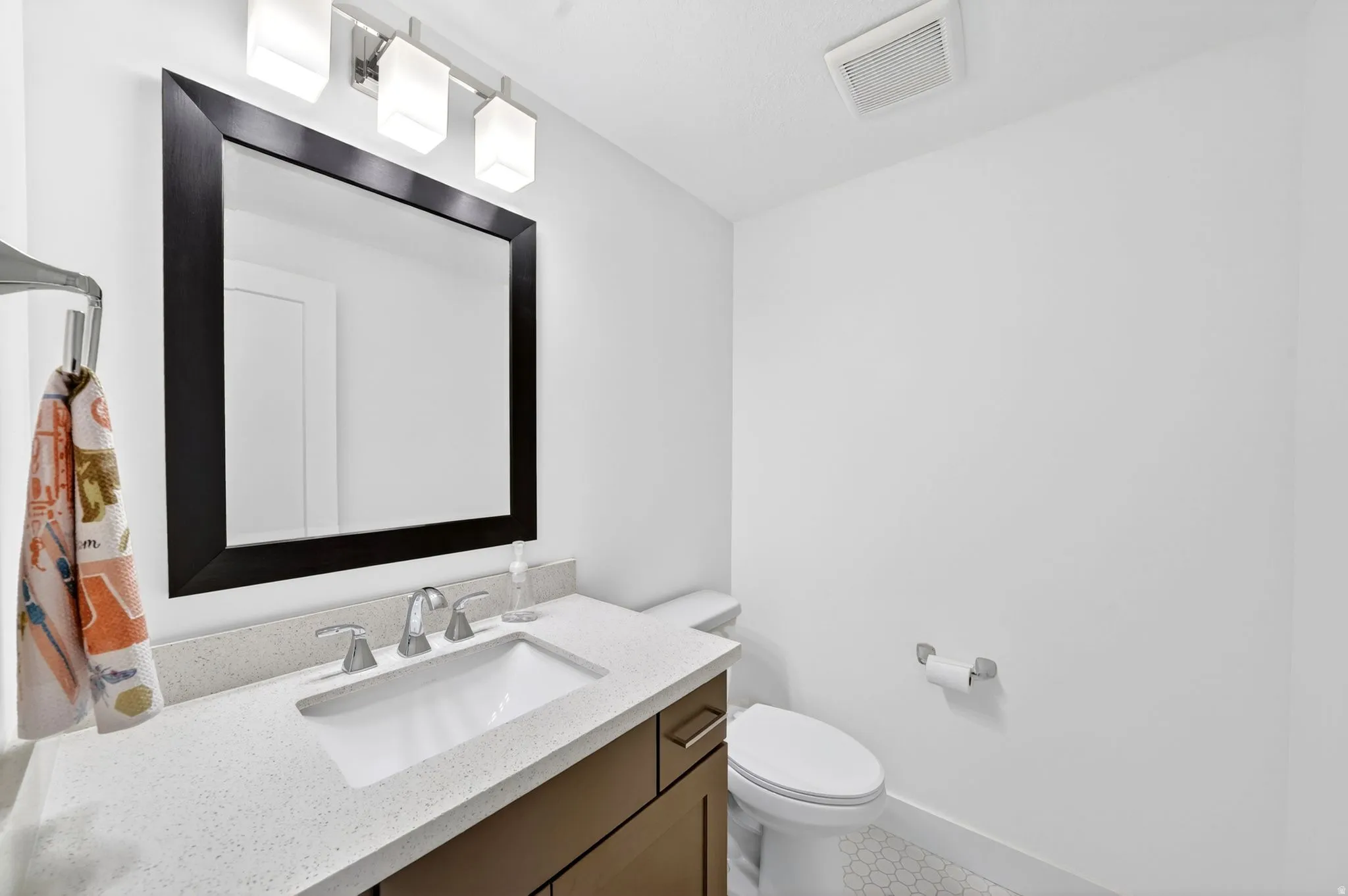 1/2 Bathroom vanity featuring an integrated sink, polished chrome faucet, and a framed mirror