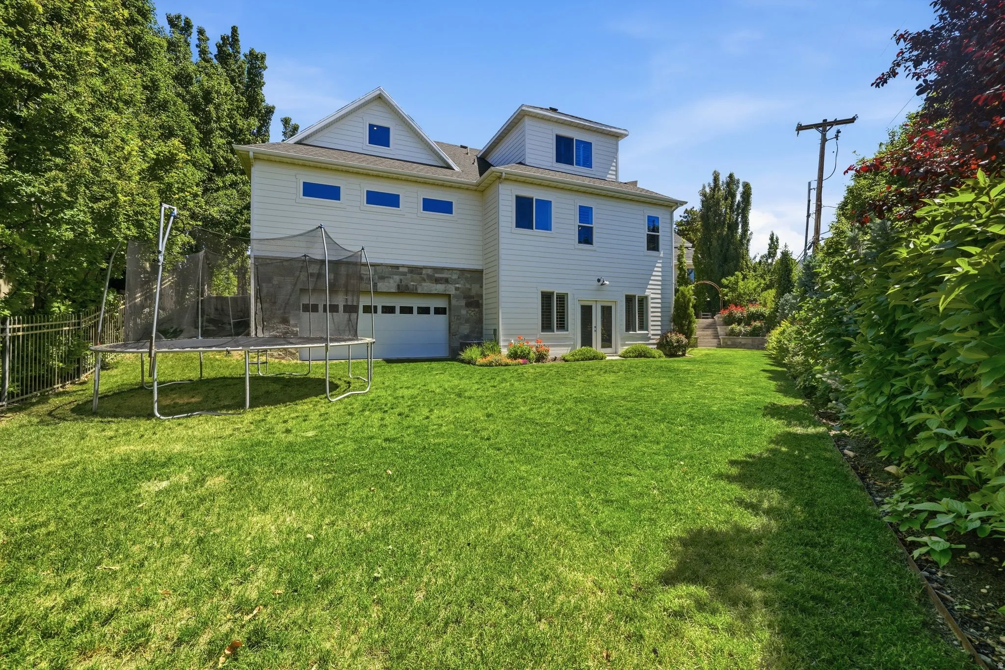 Expansive green lawn with mature perimeter landscaping
