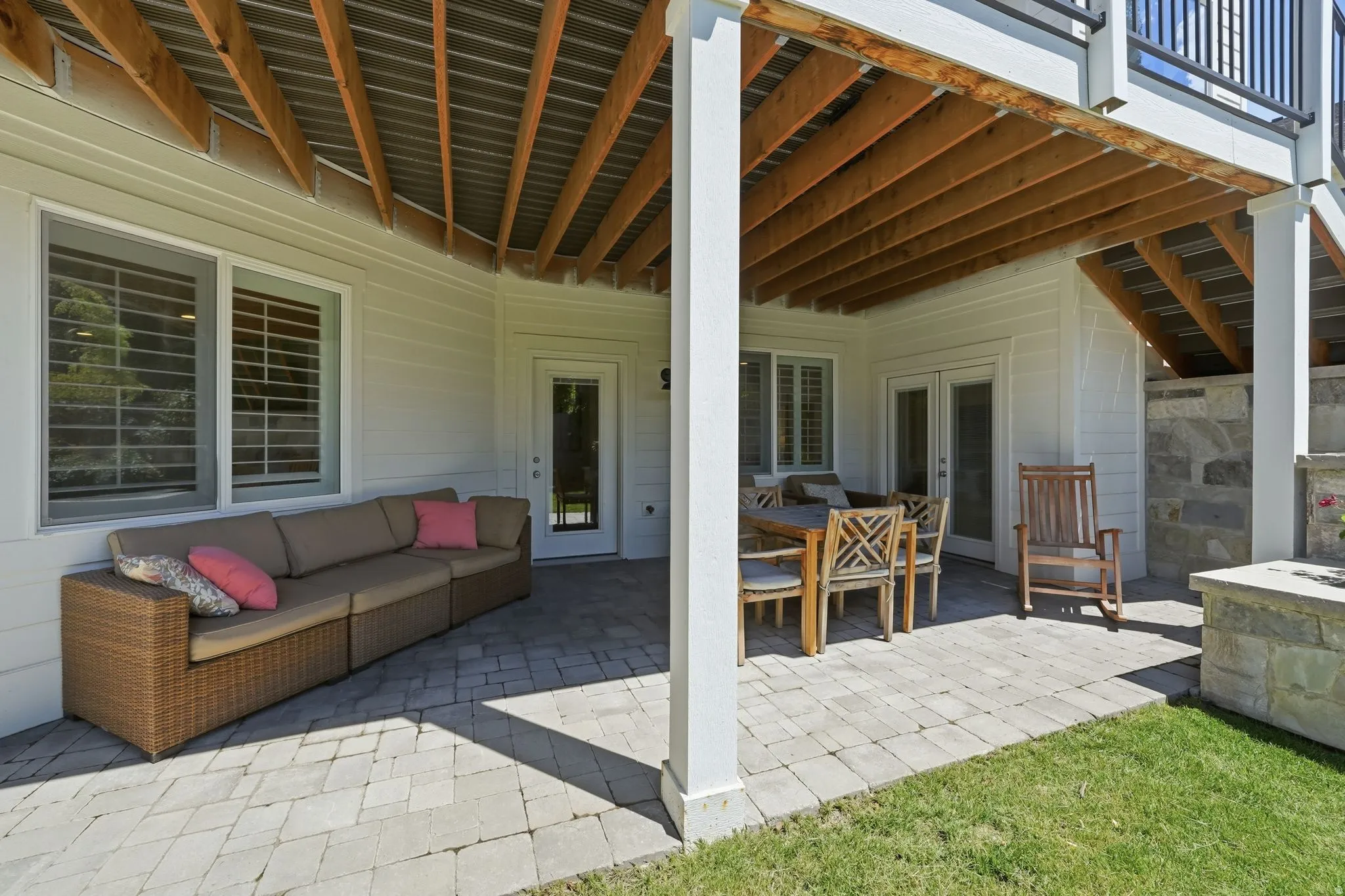 Covered patio featuring an exposed wood beam ceiling and white siding