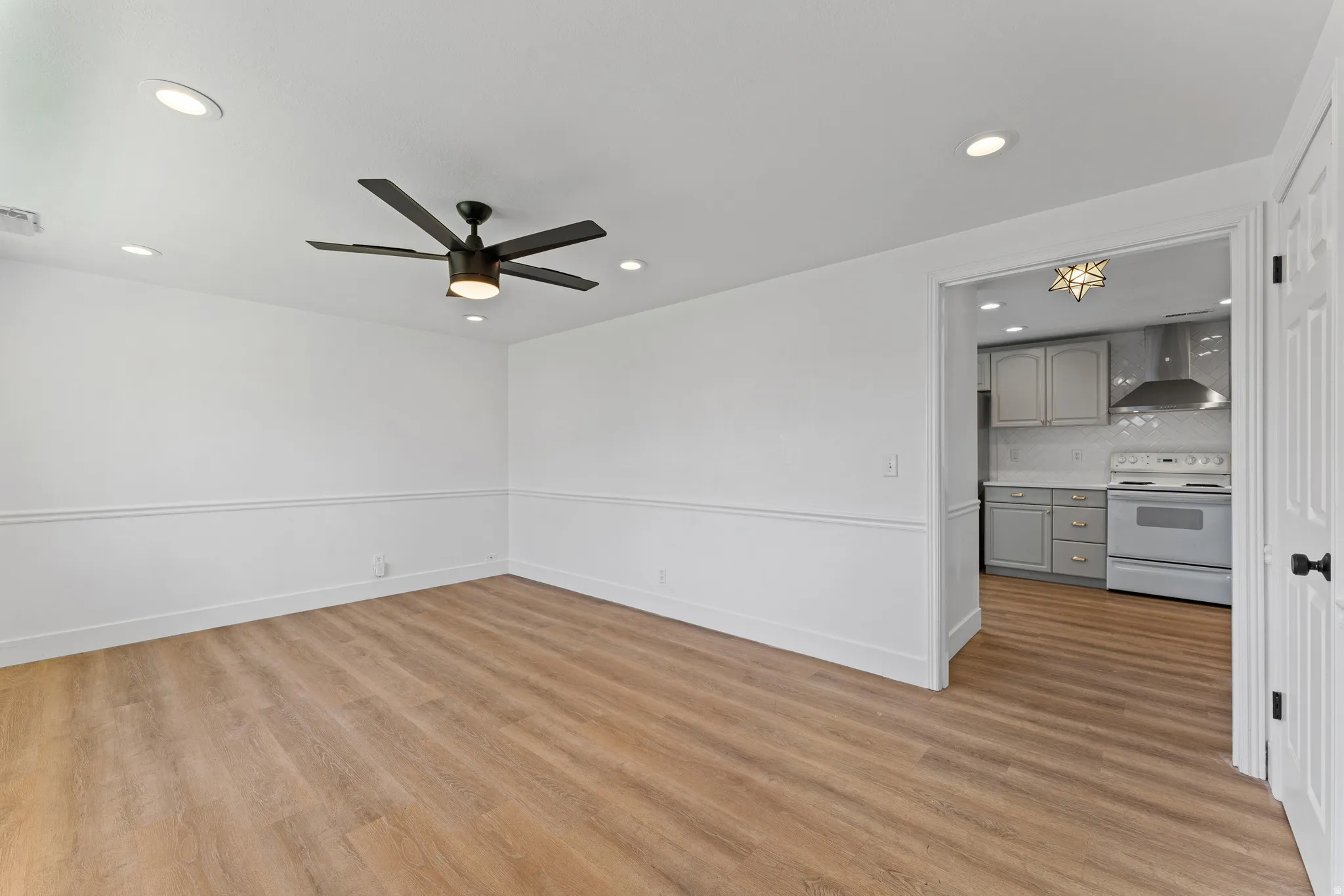 Open concept living space featuring wood-finish flooring, recessed lighting, and a contemporary ceiling fan