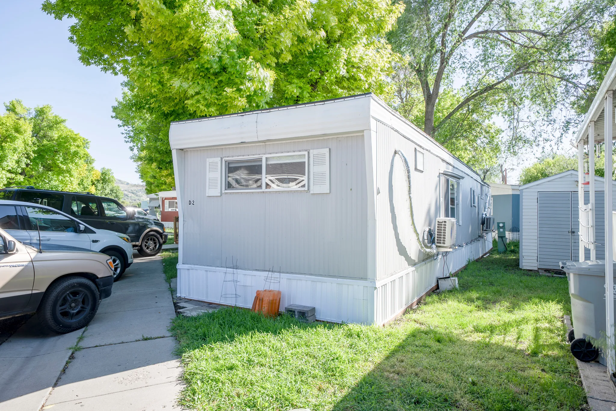 Light gray manufactured home with white trim and white window shutters