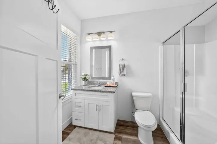 Bathroom featuring a white vanity with a stone-finish countertop, undermount sink, and chrome faucet