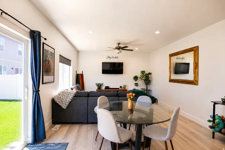 Open-concept living area with wood-finish flooring, recessed lighting, and a ceiling fan