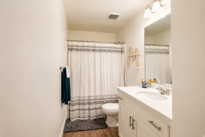 Contemporary bathroom featuring a single vanity with an integrated sink, white countertop, and brushed nickel faucet