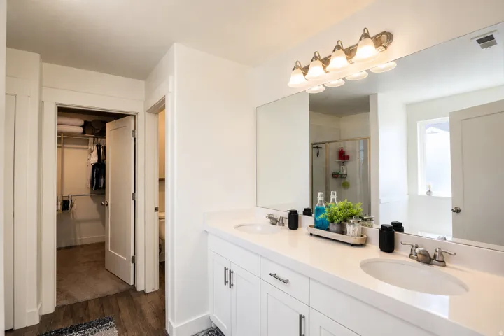 Dual vanity with undermount sinks, white cabinetry, and brushed nickel hardware