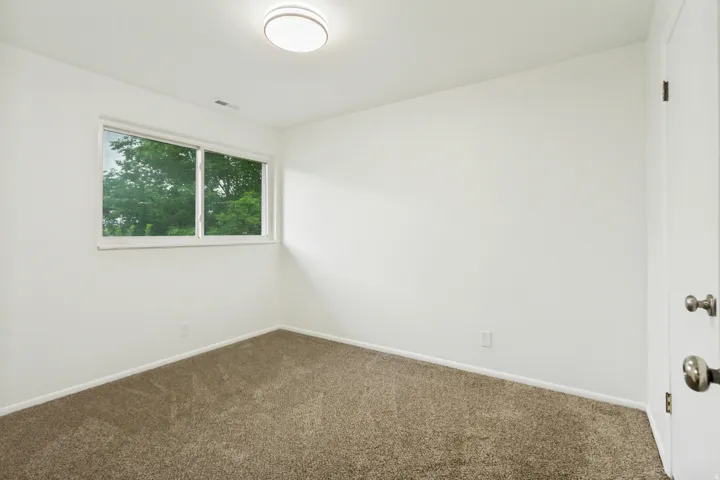 Bright room with neutral wall paint and plush carpeting