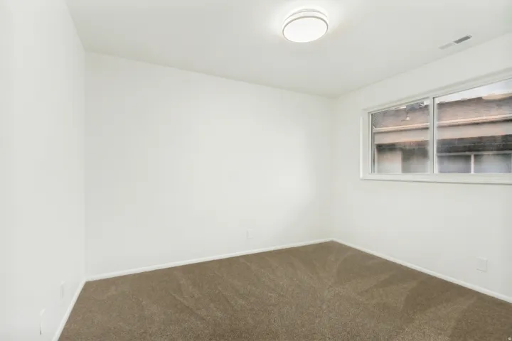 Neutral interior space featuring light-colored walls and brown carpeting