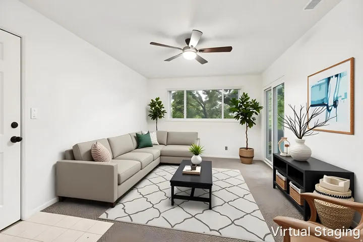 Bright living space featuring white walls, a ceiling fan, and carpeted flooring