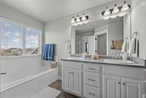 Double vanity with white cabinetry, dual undermount sinks, and a single large mirror
