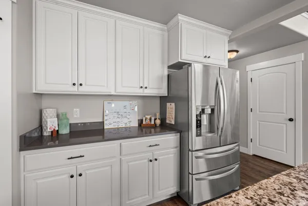 White shaker-style cabinetry with crown molding and dark hardware