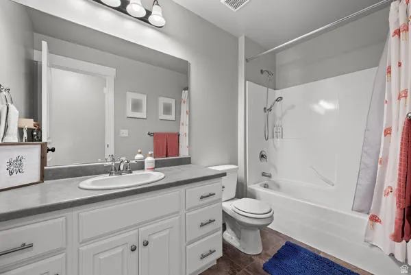 Bathroom featuring a white vanity with a single basin sink, a gray countertop, and overhead vanity lighting