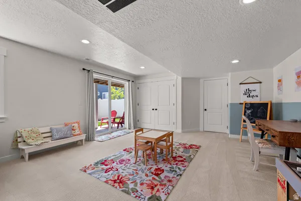 Carpeted room featuring a sliding glass door, recessed lighting, and white trim