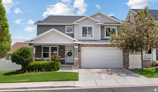 Two-story residence featuring a gray exterior with white trim and stone accents