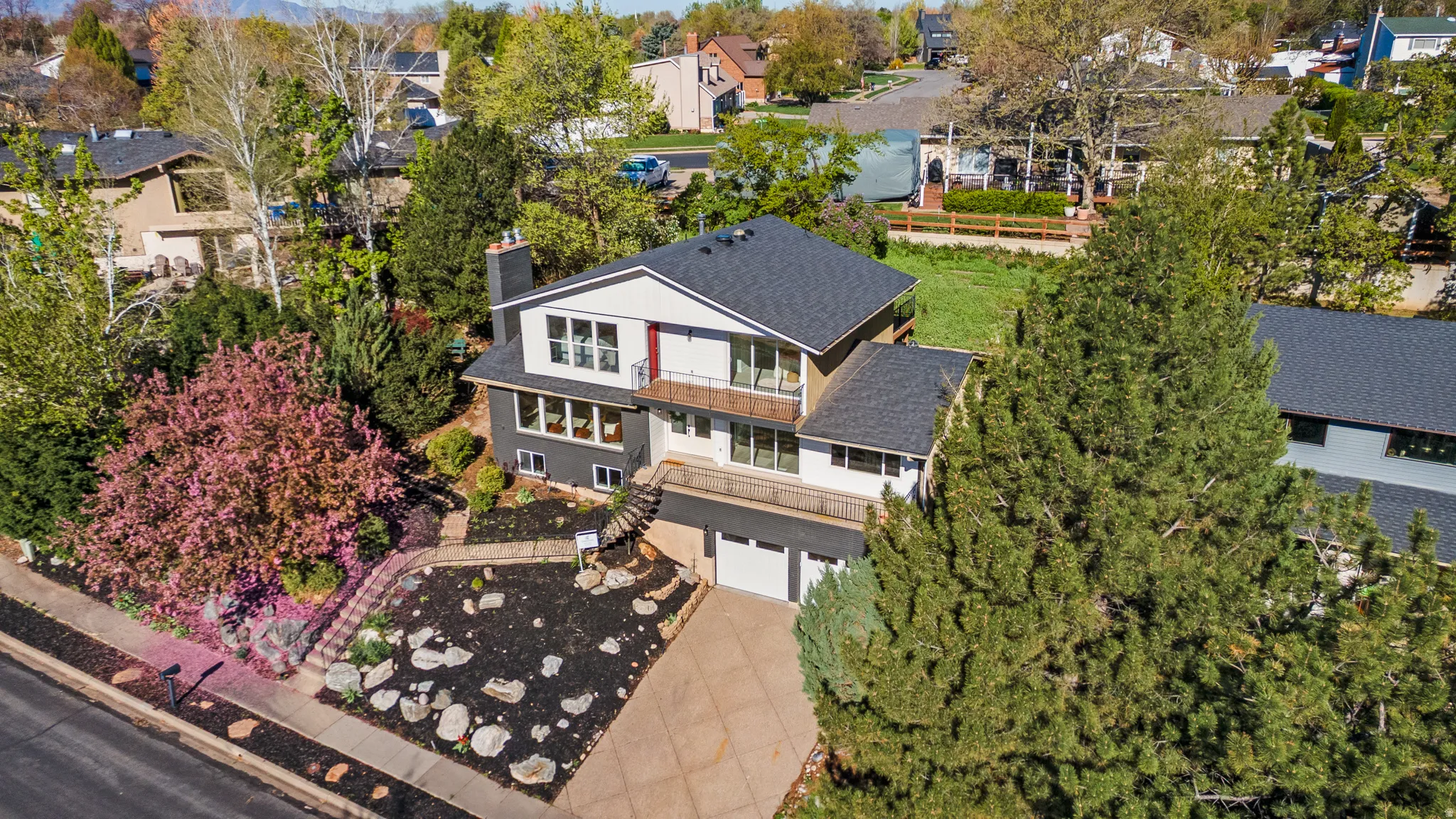 Multi-level residence featuring a gray and white exterior with a red accent panel