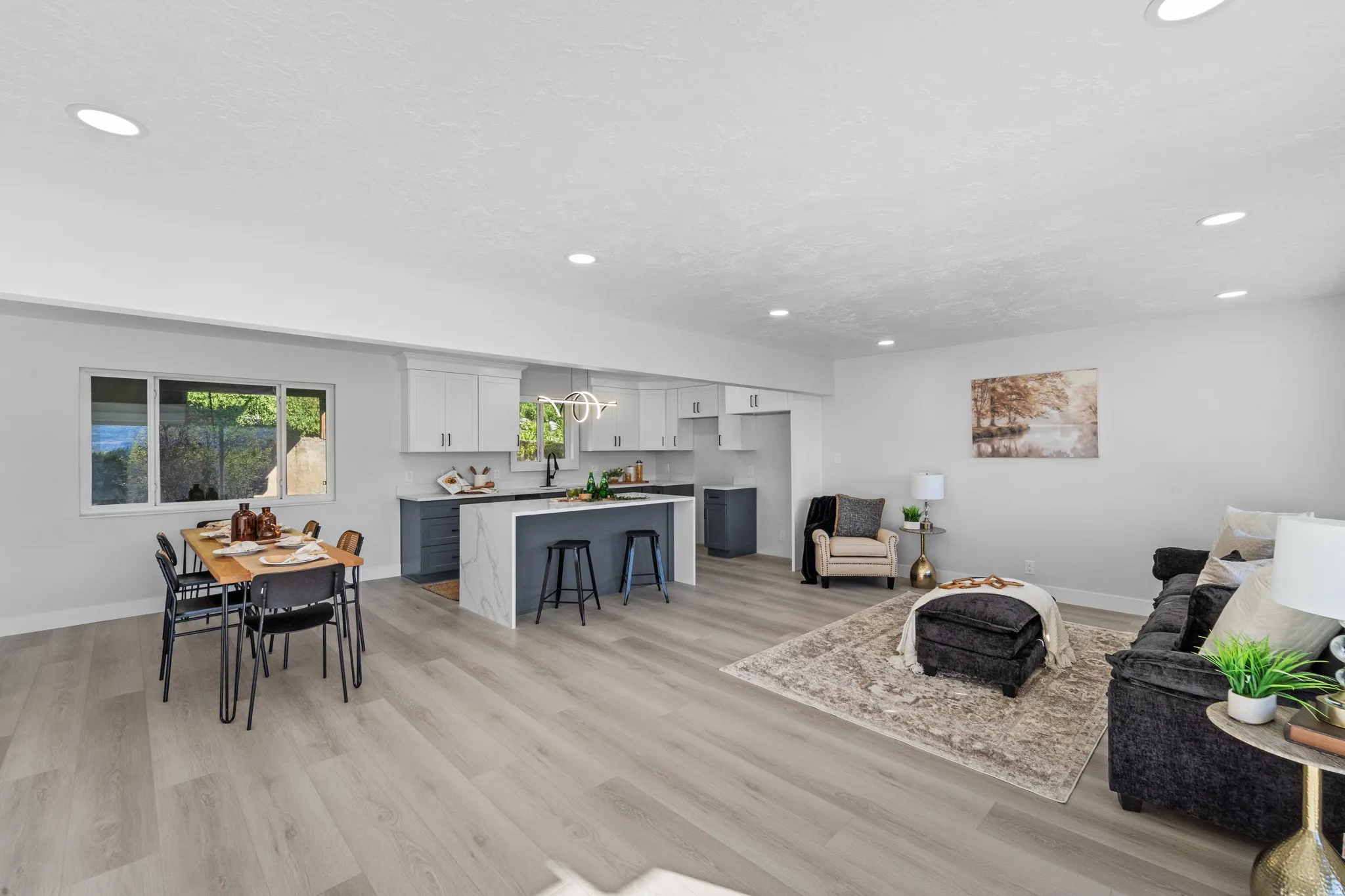 Open-concept living space featuring wood-finish flooring, recessed lighting, and a modern kitchen