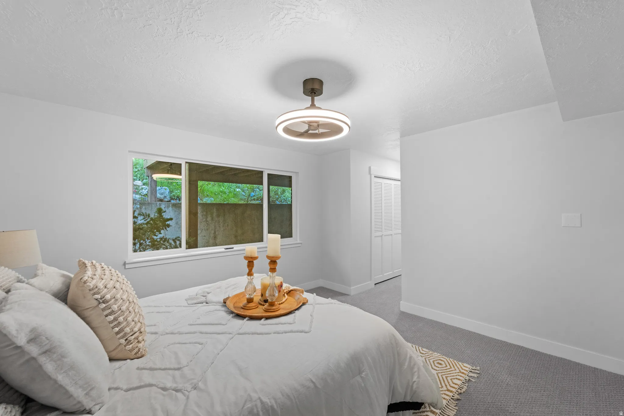 Recessed window with white frame, textured gray carpeting, and a contemporary ceiling fixture