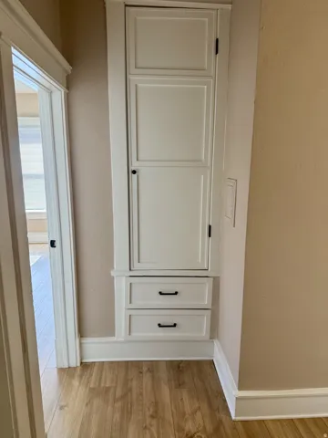 Built-in white paneled cabinetry featuring two lower drawers with matte black hardware