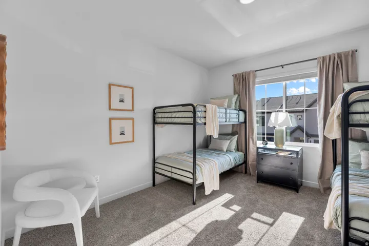 Bright room with a large window, soft gray carpeting, recessed ceiling lighting, and crisp white walls