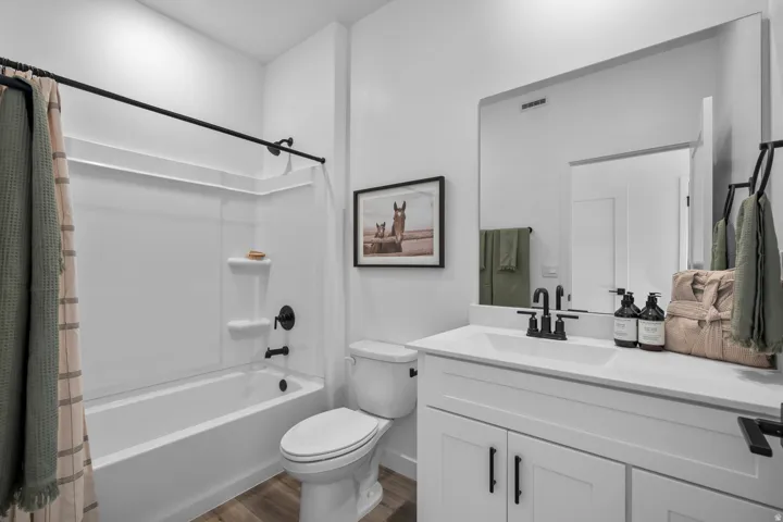 Bathroom with a white vanity featuring shaker-style cabinetry and a white countertop