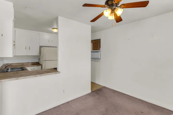 Kitchen with white cabinetry, a built-in refrigerator, and a pass-through counter