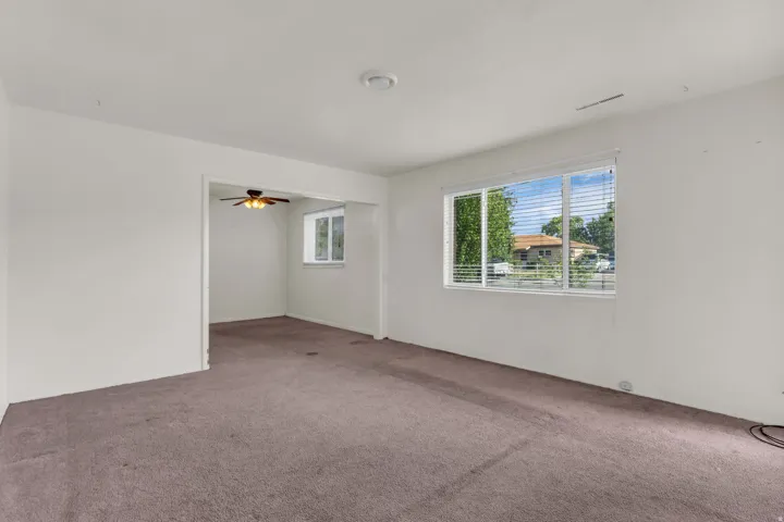 Expansive interior space featuring light-colored walls and neutral carpeting