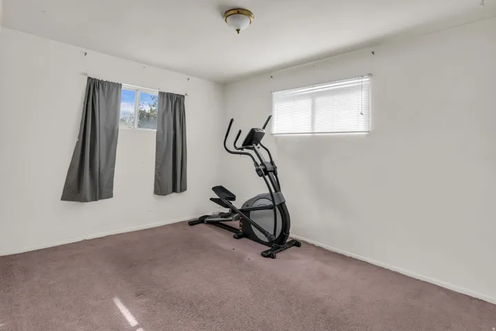 Carpeted interior room featuring white walls and baseboards
