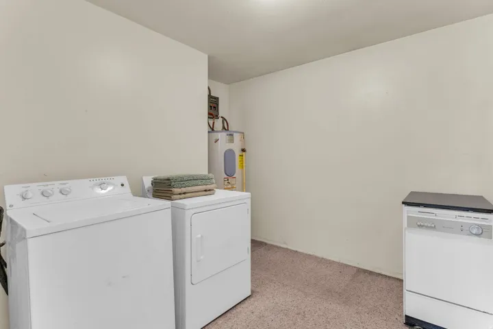 Dedicated laundry area featuring a top-load washing machine, front-load dryer, and a freestanding dishwasher