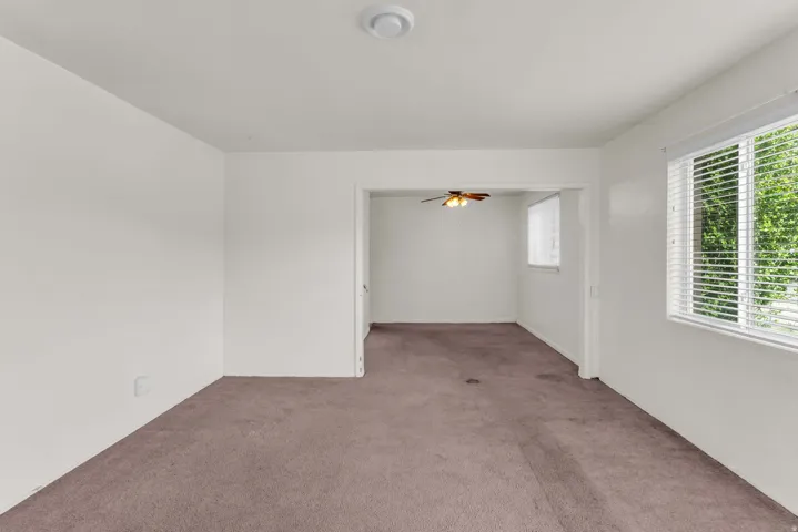 Carpeted interior space with white painted walls and a flush-mount ceiling light