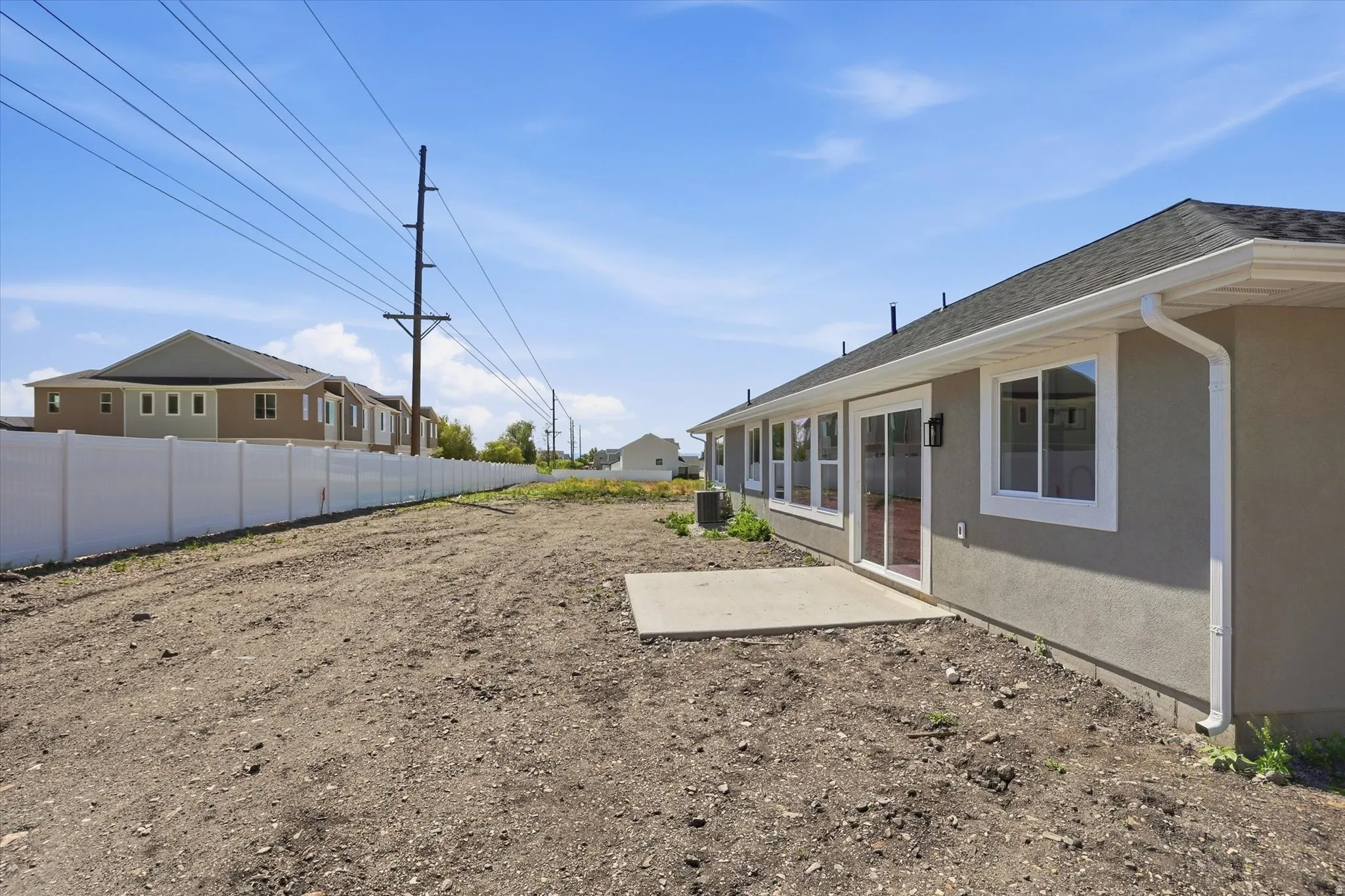 Spacious backyard with a new concrete patio, vinyl privacy fencing, and ample room for customization