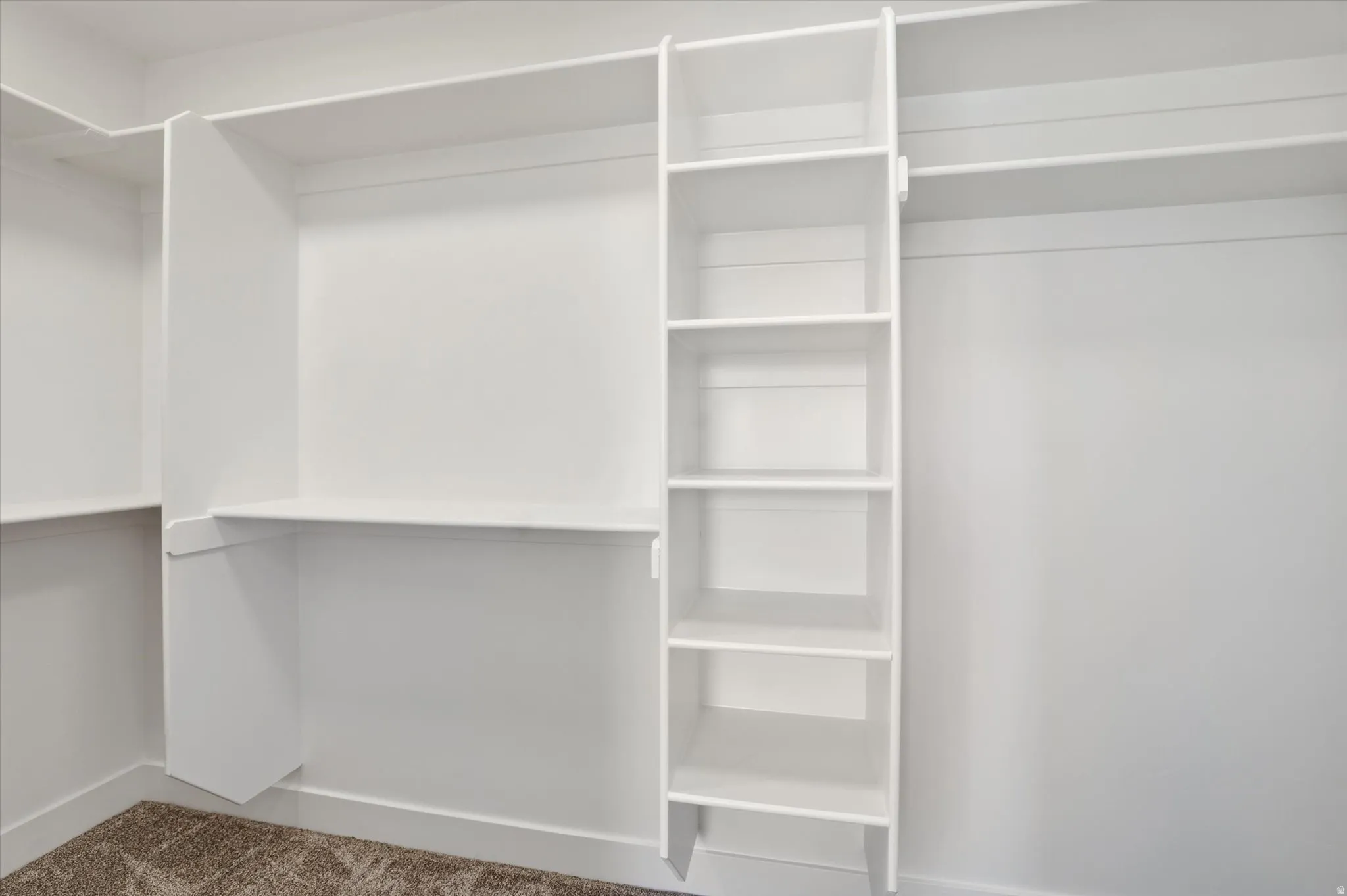 Custom closet system featuring white shelving, hanging rods, and integrated storage