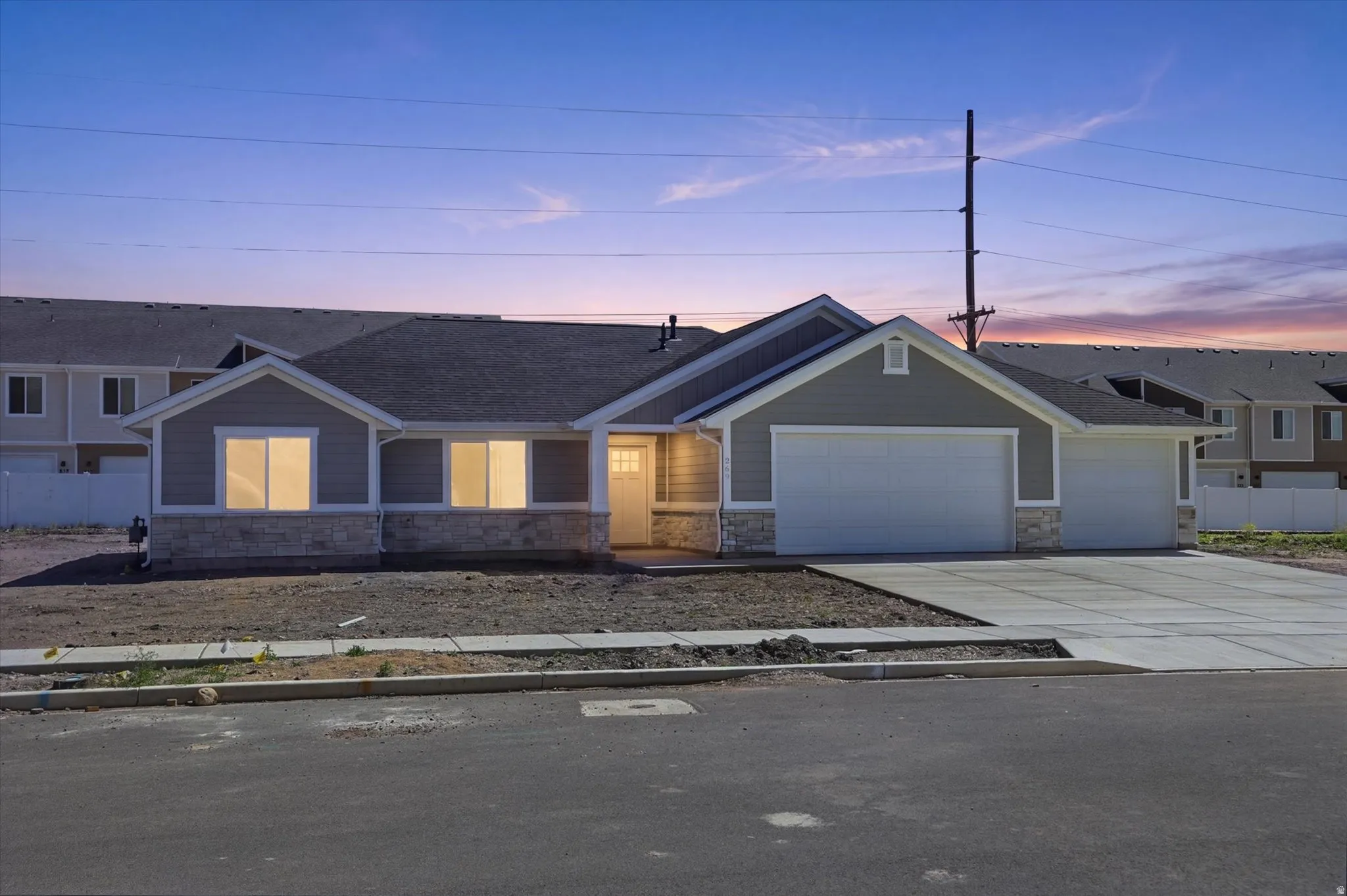 Contemporary ranch-style exterior featuring gray siding and a stone facade