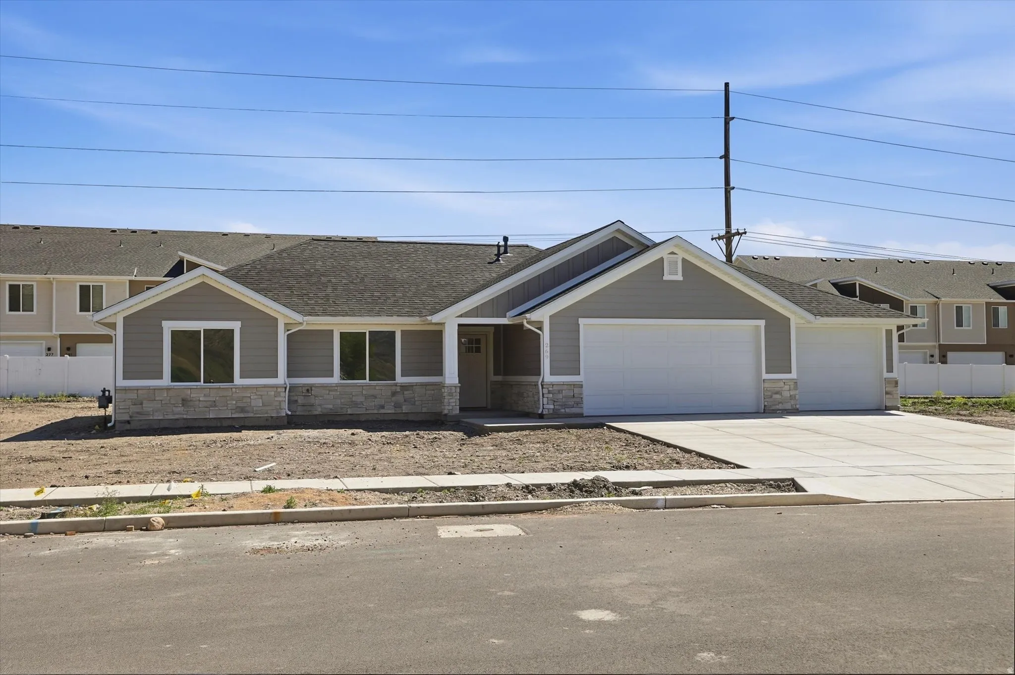 Ranch-style exterior with gray siding and stone veneer accents