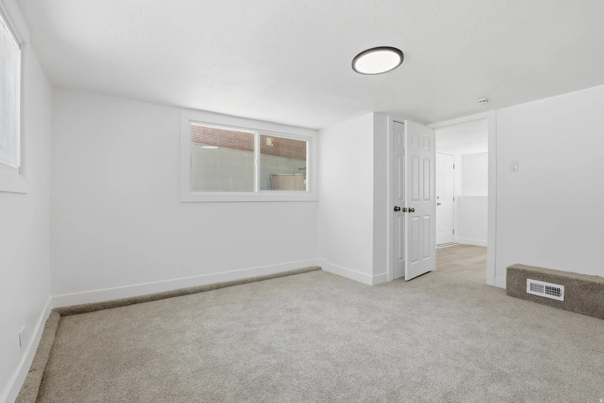 Neutral-toned carpeted room featuring white walls and trim