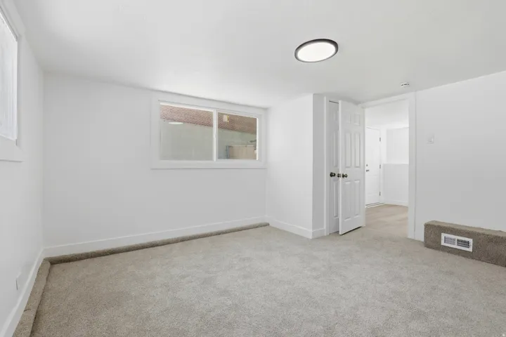 Neutral-toned carpeted room featuring white walls and trim