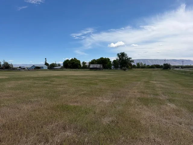 Expansive land parcel featuring open fields and distant mountain ranges