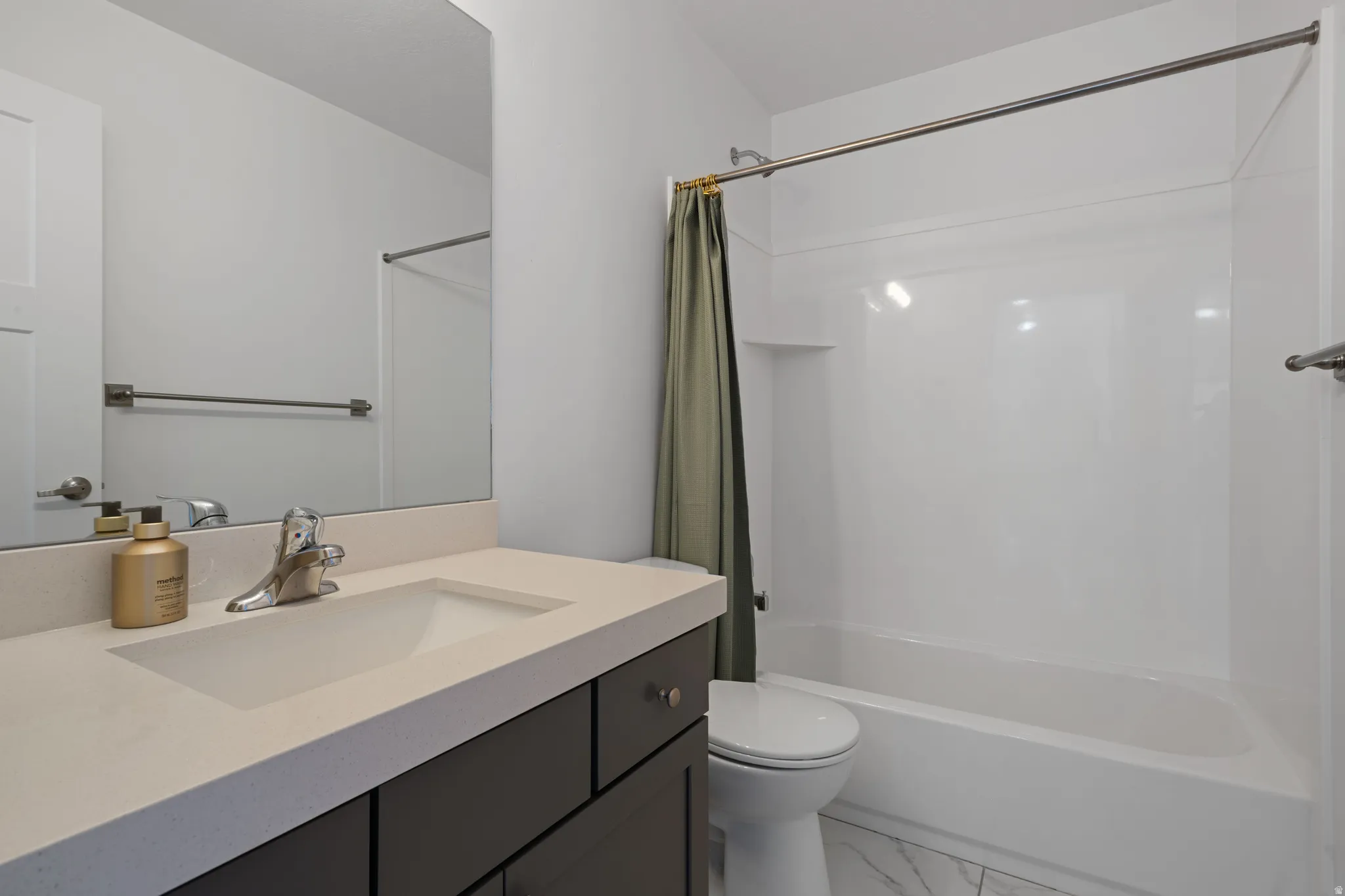 Bathroom featuring a white integrated sink, light-colored countertop, and dark-finish vanity with drawer storage