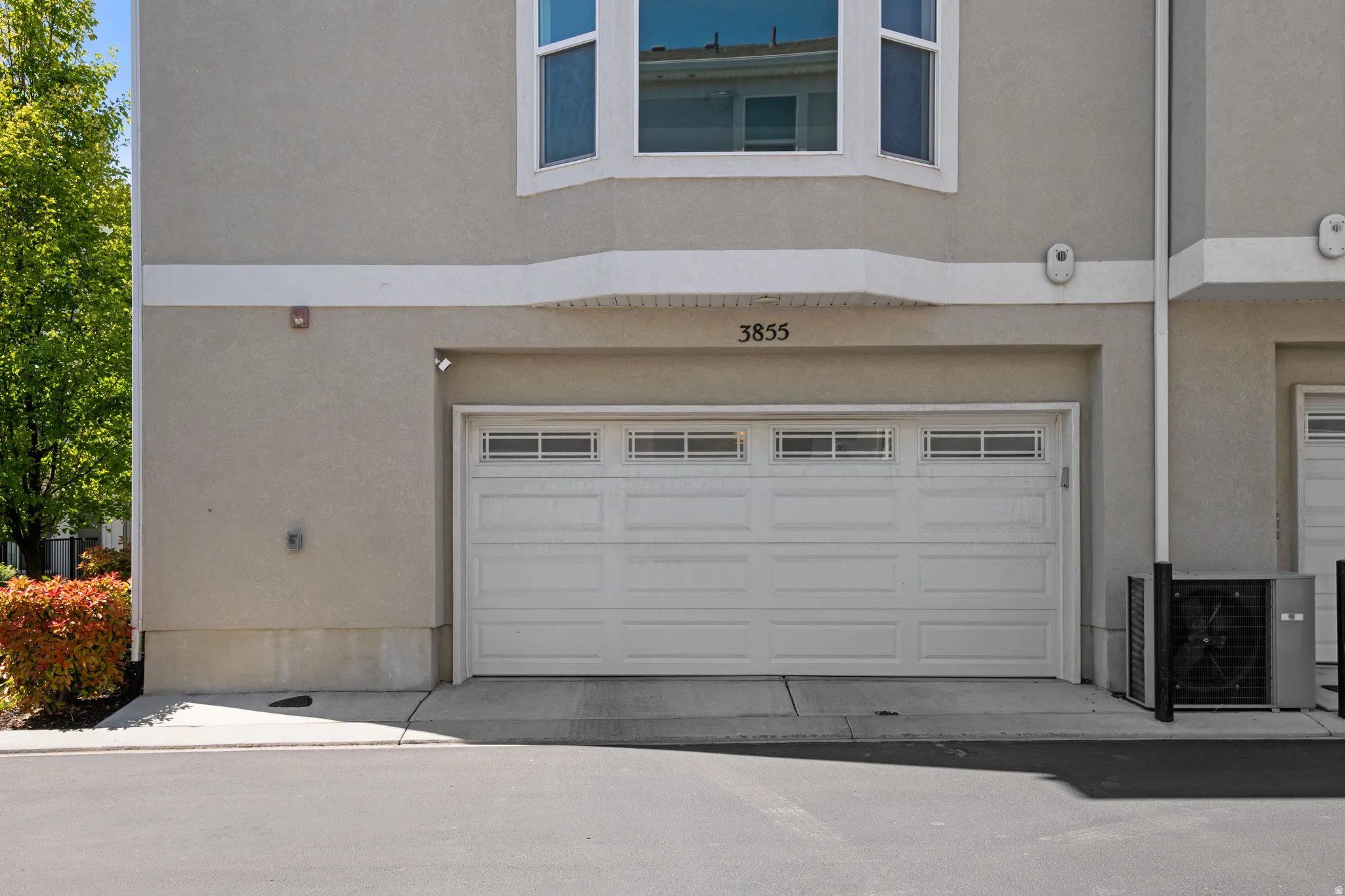 Attached garage with a white paneled door featuring upper window inserts