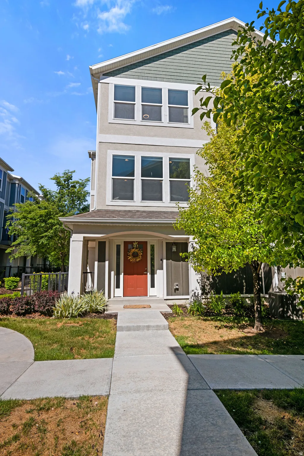 Three-story townhouse featuring a stucco and siding exterior