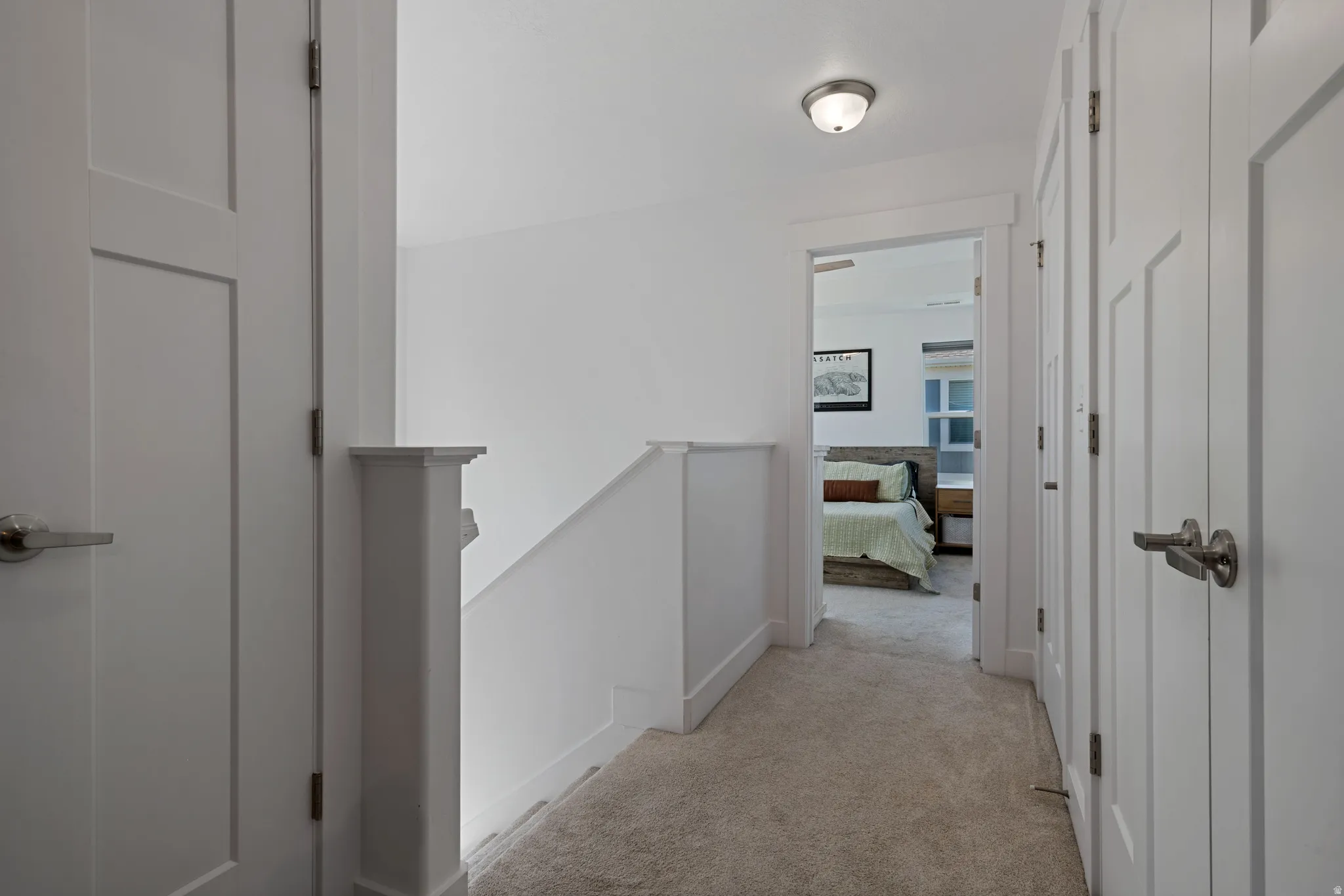 Hallway featuring a neutral carpet, white walls, and bright white trim